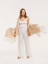 Pantalón negro de lino, tiro alto, corte palazo, con elástico en la pretina trasera, cierre delantero y broche interno. Tiene bolsillos laterales, dobladillo invisible y tajos a los costados.