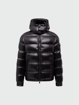 Campera puffer corta de Moncler, modelo Maya, con acabado brillante, capucha desmontable y cierre frontal con cremallera. Presenta bolsillos laterales y un bolsillo con solapa en la manga izquierda.