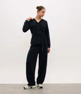 Campera utilitaria deportiva marrón de poliamida, con capucha, cierre frontal de botones, bolsillos con solapa en el pecho y lazo ajustable en la cintura.