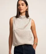 Blusa sin mangas de poliéster satinado color beige con estampado geométrico y cuello alto drapeado.