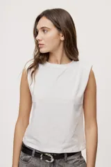 Remera sin mangas negra con cuello redondo y hombros estructurados con hombreras, de corte recto y largo a la cintura.