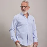 Camisa de manga larga confeccionada en algodón oxford, con estampado de rayas verticales finas en color azul y blanco. Presenta cuello americano button-down y cierre frontal con botones.