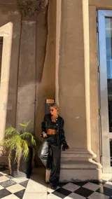 Pantalón de corte wide leg en color negro, confeccionado en material con acabado tipo cuero, de tiro medio y diseño holgado.