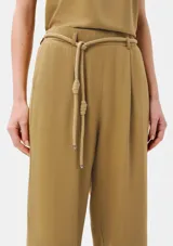 Pantalón de corte recto color beige con pinzas en la parte delantera y tira ajustable a modo de cinturón con nudos decorativos.