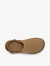 Zueco de la marca UGG modelo Goldenstar, confeccionado en cuero nobuck negro. Presenta una suela de plataforma de EVA ultra liviana y una correa trasera ajustable con hebilla metálica dorada.