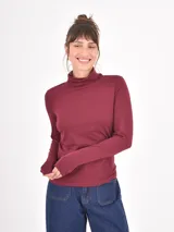 Polera de manga larga en color bordó, con cuello alto y ajuste al cuerpo.