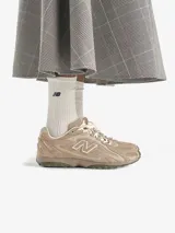 Championes urbanos New Balance modelo 204L, de perfil bajo con diseño inspirado en el running de los años 2000. Confeccionados en gamuza de primera calidad en tonos beige, presentan líneas arqueadas en las superposiciones y el logo N característico en los laterales.