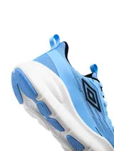 Championes de running Umbro modelo Dynamen para mujer, en color negro con suela blanca gruesa y detalles en celeste.
