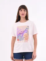 Remera blanca de manga corta con estampado frontal de una tortuga marina rodeada de corales y la frase "OCEAN LIFE".