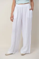 Pantalón palazzo de lino color blanco, con cintura elástica fruncida, bolsillos laterales y detalle de alforzas verticales en los laterales.