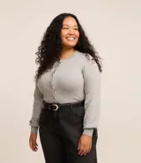 Cardigan gris de punto con cuello redondo, manga larga ajustada y bajo ajustado. Cierre frontal con botones.