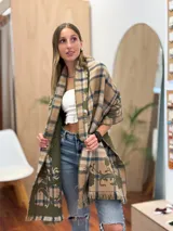 Bufanda rectangular con estampado a cuadros en tonos beige, azul y verde. Tiene flecos en los extremos y un estampado floral en el interior.