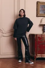 Pantalon de tiro alto confeccionado en ecocuero, con diseño semi oxford y cierre metálico lateral. Presenta un recorte horizontal sobre la rodilla.