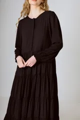 Vestido midi negro con corte en la cintura y falda amplia con volados.