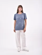 Remera azul con estampado de estrellas blancas, cuello redondo y mangas cortas con frunce en los hombros.
