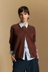 Cardigan de tejido de punto color rojo, con cuello redondo, cierre frontal de botones al tono y puños acanalados.
