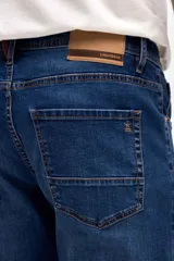 Jean de corte slim, ajustado desde la cadera hasta los tobillos, en color azul oscuro con costuras en contraste.