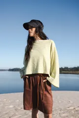 Remerón de punto con diseño de rayas horizontales en color verde lima y blanco. Presenta una silueta oversize, cuello a la base y mangas largas anchas. Confeccionado en tejido de algodón liviano.