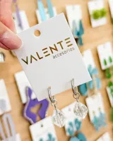 Aros tipo argolla de acero con dije colgante de cristal facetado en forma de rombo.