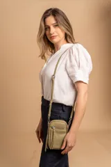 Bandolera compacta color rosado, con correa regulable y desmontable. Tiene apertura superior, bolsillo frontal con cierre y detalle de borla, y bolsillo trasero sin cierre. El interior está forrado en tela y cuenta con un bolsillo adicional.