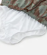 Bermuda de baño para hombre, color verde salvia con estampado de palmeras y vegetación en tono marrón. Posee cintura elástica con cordón de ajuste marrón y calzoncillo interior de malla.