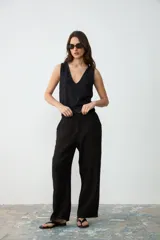Musculosa de punto color negro con sutil brillo plateado, escote en V pronunciado y ribetes acanalados en el ruedo.