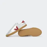 Championes Veja Volley plateados con logo lateral en rojo y suela de goma color caramelo.