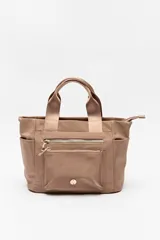 Cartera negra de nylon con diseño compacto y funcional. Cuenta con asas cortas y correa regulable desmontable para llevar al hombro o cruzada, además de múltiples bolsillos con cierre y detalles dorados.