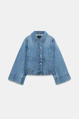 Campera de denim azul con cuello solapa, cierre frontal de botones metálicos, bolsillos delanteros de plastrón y mangas largas acampanadas.