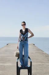 Chaleco calado negro con diseño de rayas diagonales rojas, beige y blancas.