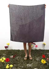 Pañuelo cuadrado de gran tamaño en color gris oscuro, con estampado tipográfico repetitivo de la palabra 'CAPER' en líneas finas de color blanco.