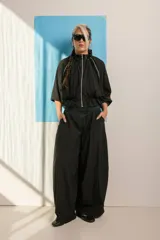 Campera negra de tela sintética con cierre frontal, cuello alto, mangas 3/4 con puños elásticos y cintura ajustable con cordón.