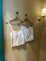 Pollera corta de encaje blanco con cintura elástica y diseño de corte recto.