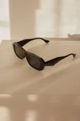 Lentes de sol con diseño estructurado, líneas limpias y frente recto en color negro.
