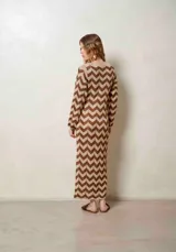 Vestido largo de lurex con diseño de patrón en zigzag en tonos tostado y marrón, escote en V con cordones para atar y mangas largas.