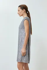 Vestido corto plateado con lentejuelas, escote en V y mangas cortas.