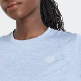 Remera deportiva New Balance de manga corta, color celeste melange, con cuello redondo y logo reflectante en el pecho.