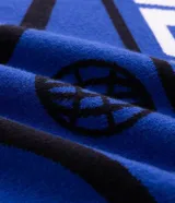 Remera de tricot liviano Blue Steel con corte boxy, cuello polo alto y cierre frontal parcial de un cuarto. Presenta diseño jacquard integral con gráficos y lettering en tonos azul, negro y blanco, mangas cortas y estilo de inspiración deportiva.