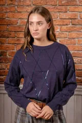 Sweater de punto color gris oscuro con diseño de rombos formados por lentejuelas brillantes, cuello redondo y mangas largas con puños acanalados.