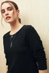 Top marrón de manga larga con textura metalizada y acabado glitter.