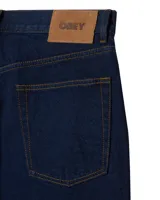 Pantalón de jean estilo baggy, de corte holgado y tiro medio, en color negro lavado. Cuenta con cinco bolsillos tradicionales, cierre de botón y bragueta con cremallera.