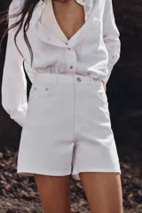 Shorts de jean tiro alto con diseño mom fit, cinco bolsillos y cierre frontal con cremallera y botón.