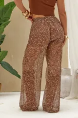 Pantalón largo color marrón con tejido de red transparente y apliques de brillos plateados, de tiro alto y corte ancho.