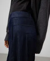 Pantalón de denim azul marino, corte barrel fit, confeccionado en algodón 100%. Presenta pespuntes a tono, trabillas, cierre de botón metálico, canesú en la espalda y bolsillos traseros.