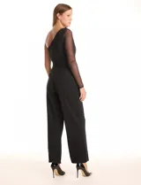 Enterito negro de crepe premium con caída pesada y fluida. Presenta un escote asimétrico, una única manga larga de mesh transparente y pierna de corte recto. Incluye bolsillos laterales invisibles y cierre invisible en la espalda.