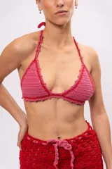 Top de bikini tejido a crochet color rosa con terminaciones en rojo y tirantes finos.