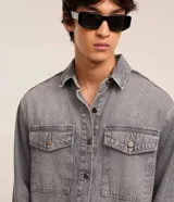 Camisa masculina de denim de algodón con efecto marmolado, corte oversized tipo boxy, cuello camisero, mangas largas, cierre frontal con botones y dos bolsillos frontales con solapa en el pecho.