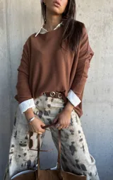 Sweater de punto color chocolate, de corte holgado y manga larga, con cuello redondo.