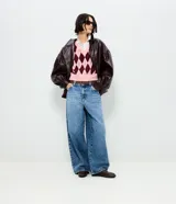 Pantalón modelo barrel de jeans confeccionado en algodón, con cintura mediana, bolsillos funcionales, cierre tradicional y perneras amplias de corte cónico. Incluye pañuelo estampado desmontable en la cintura.