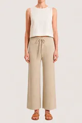 Pantalón de punto color beige, de corte recto y holgado, con cintura elástica y cordón ajustable.